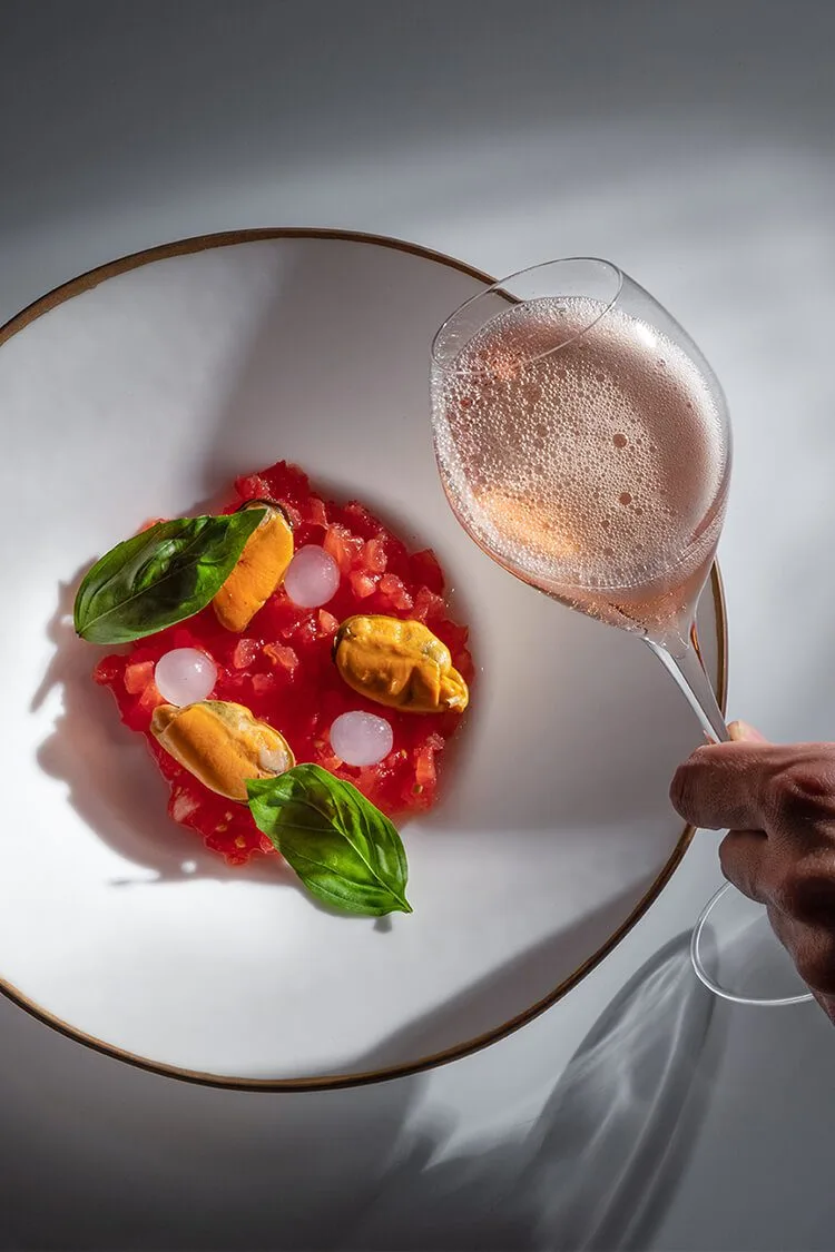 Ensalada de tomate picado con mejillones, cebolletas y laurel, junto a copa de vino rosado en el restaurante Sensacions en Barcelona, fotógrafo profesional.