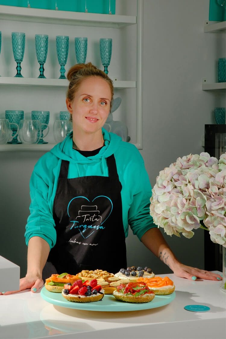 Retrato artístico con chica posando frente a mesa llena de beagles dulces y salados en Tarta Turquesa, fotografía profesional gastronómica en Barcelona.