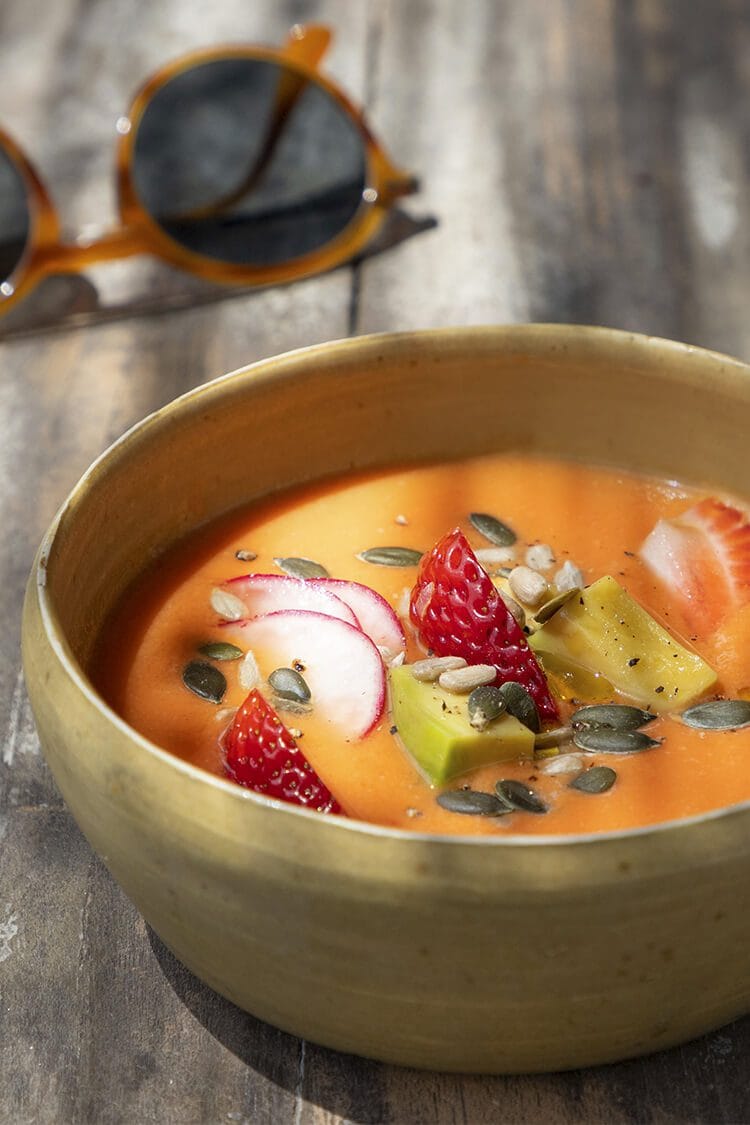 Gazpacho de frutas con trozos enteros servido en mesa exterior con luz natural, fotografía profesional en Restaurante Silver Catering, Barcelona.