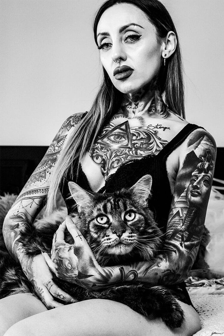 Retrato profesional en blanco y negro de Maria sentada con un gato grande sobre ella, realizado por fotógrafo de retratos en Barcelona.