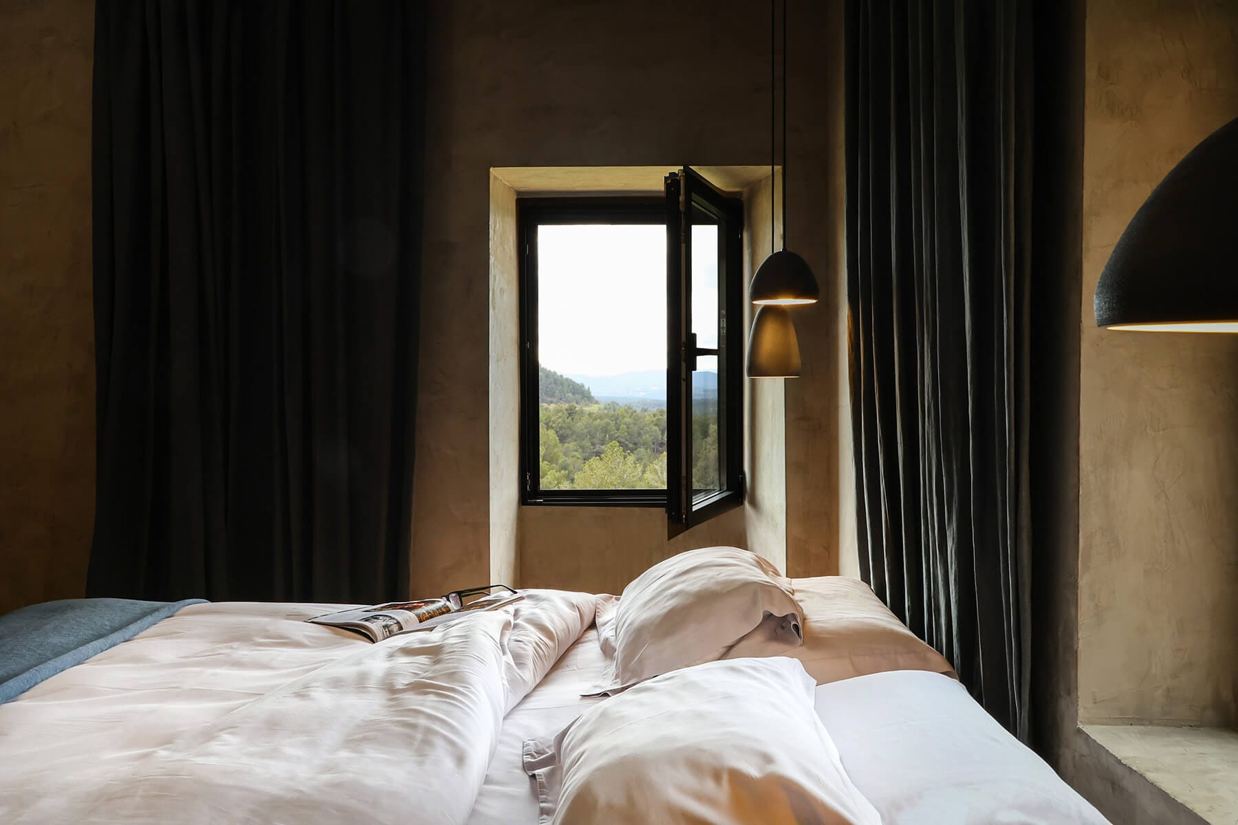 Habitación de hotel moderna en Teruel con buena iluminación, ventana al fondo y cortinas