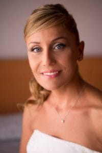 Retrato de novia sonriente con peinado elegante en boda en las costas de Barcelona