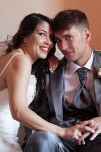 Retrato de pareja elegante sentada y sonriente en boda en Barcelona