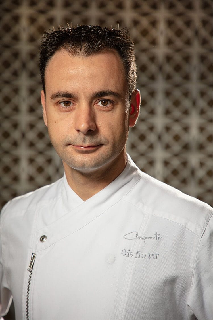 Retrato profesional de Eduard, chef del restaurante Disfrutar en Barcelona, mostrando su rostro de perfil con expresión seria y profesional.