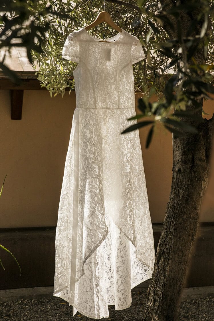 Vestido de novia blanco colgado en olivo durante boda en Barcelona