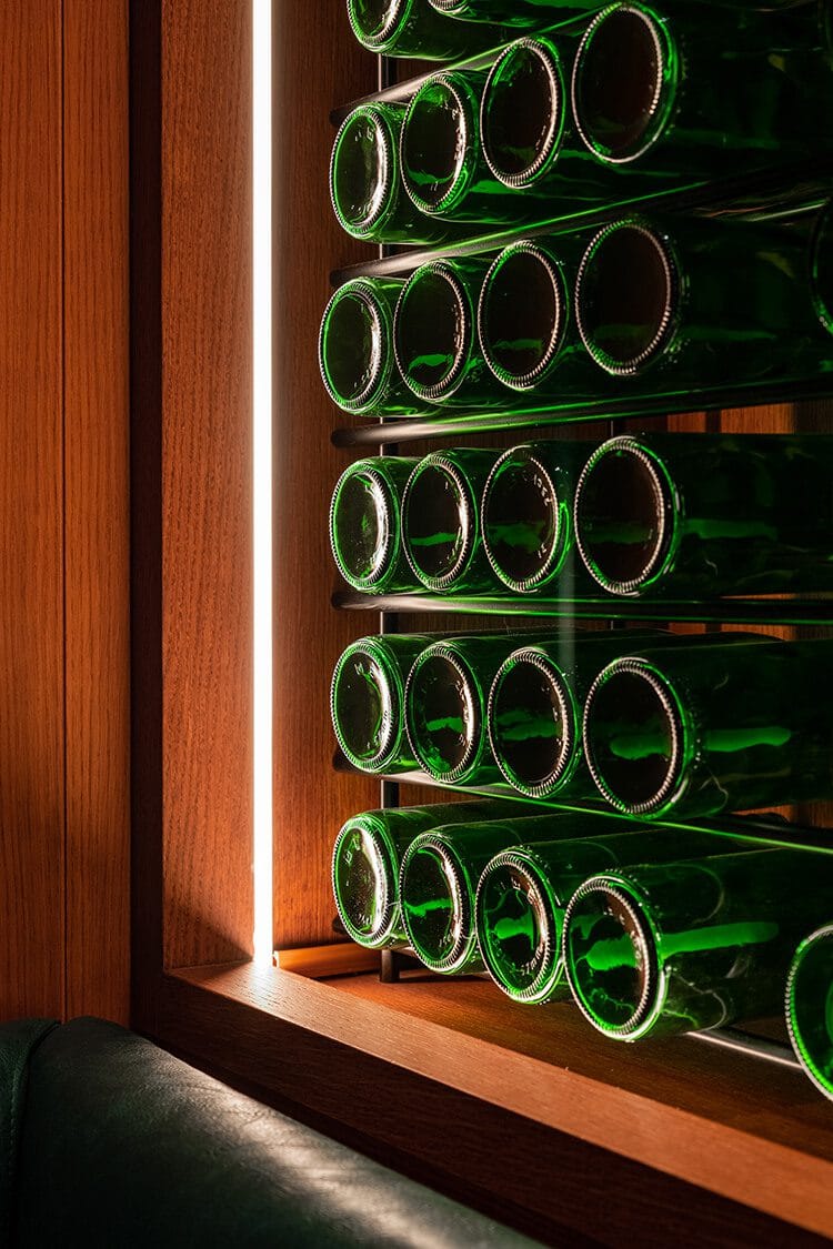 Vinoteca profesional del restaurante Txapela en Madrid con iluminación lateral y selección de vinos, fotografía gastronómica.