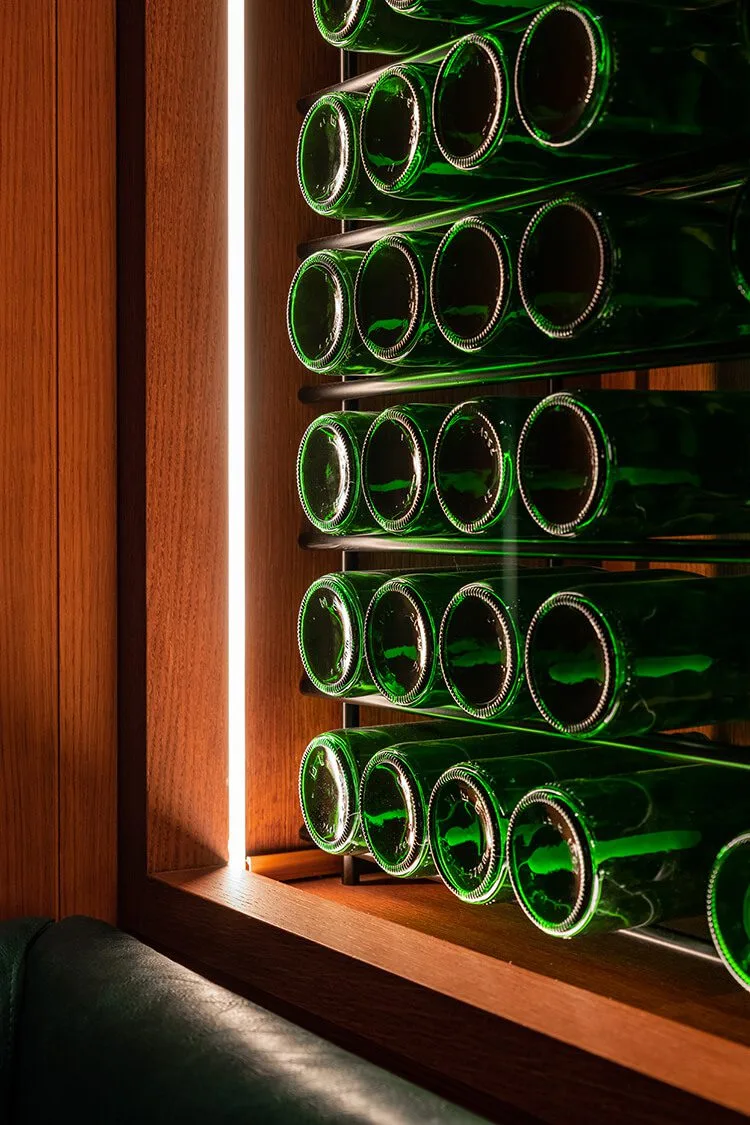 Vinoteca profesional del restaurante Txapela en Madrid con iluminación lateral y selección de vinos, fotografía gastronómica.