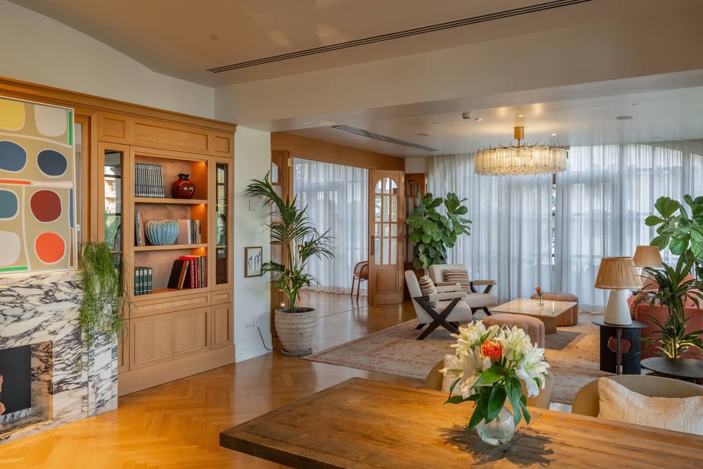 Salón vintage con estantería, chimenea y luz natural en hotel St. Regis Mardavall Mallorca