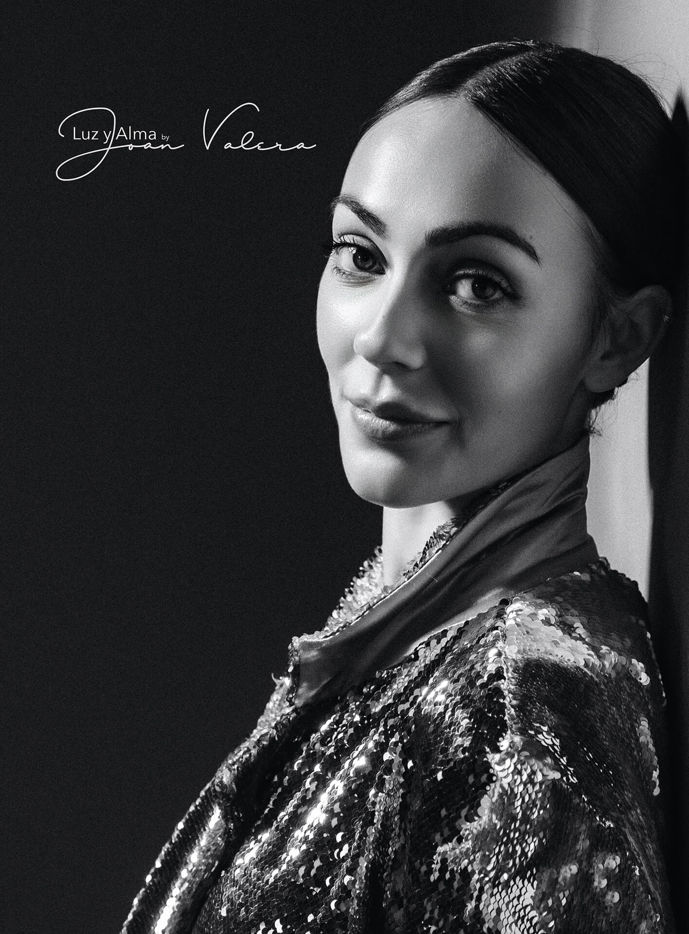 Mujer con chaqueta de lentejuelas y mirada de lado, retrato de estudio en blanco y negro con iluminación lateral dramática