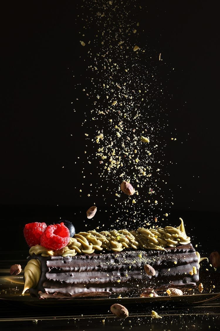Tronco de churro relleno de chocolate con lluvia de pistacho triturado y frutos rojos, fotografía publicitaria gastronómica para La Selecta