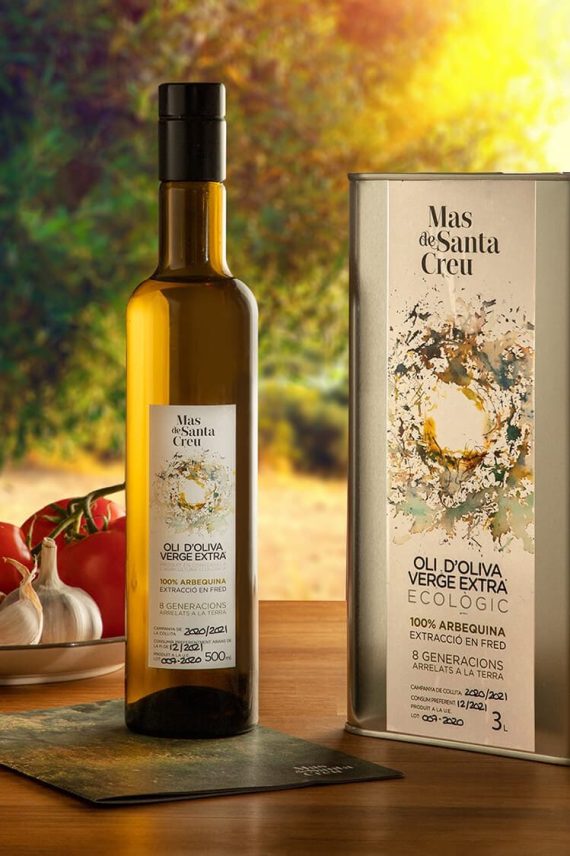 Fotografía de producto de aceite de oliva virgen extra Mas de Santa Creu variedad Arbequina sobre mesa con verduras frescas. Fotógrafo profesional de productos publicitarios en España.