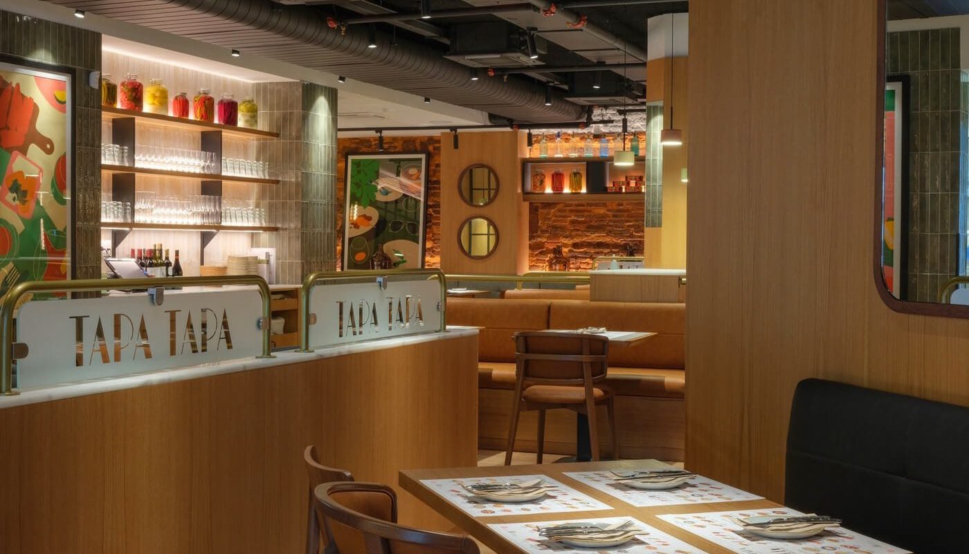 Fotografía horizontal del interior del restaurante Tapa Tapa en Barcelona con diseño moderno en madera y ambiente acogedor.